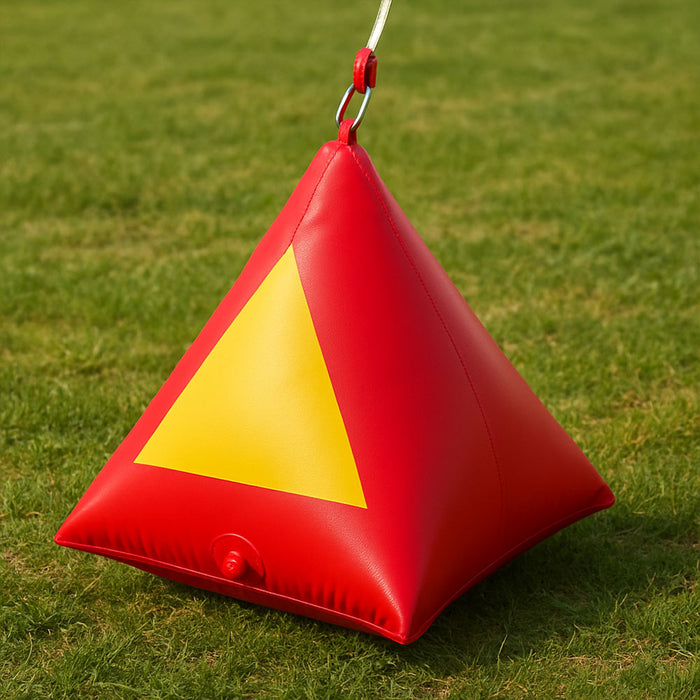 Red pyramid water-filled anchor securing an inflatable movie screen on grass (no ground staking needed).